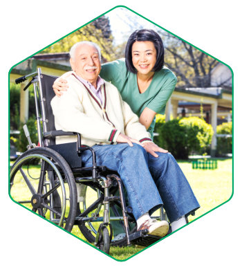 caregiver smiling with elderly man on wheelchair