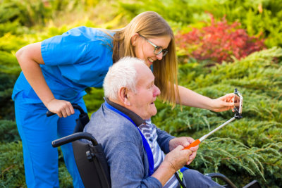 caregiver and elder man smiling