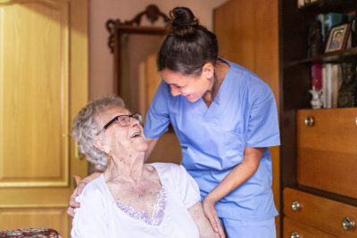 Caregiver working with happy senior people in nursing home